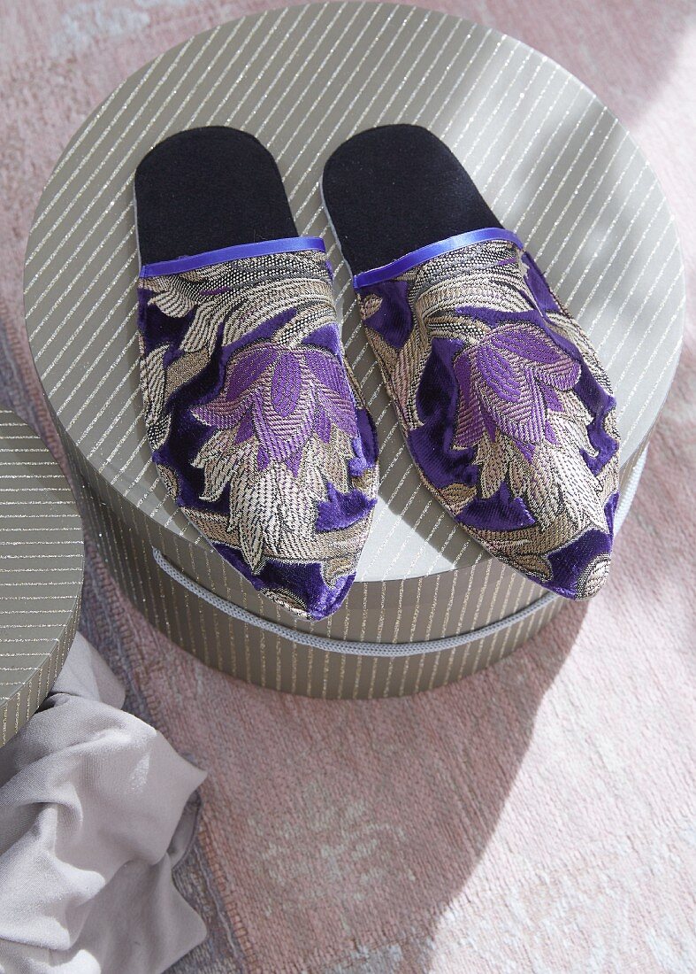 Oriental style slippers on top of a hatbox