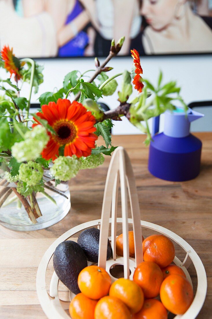 Designerschale mit Früchten und Gerberastrauß auf Esstisch