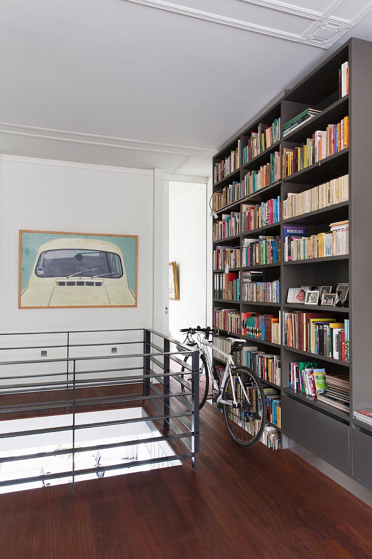 Bicycle in front of bookcase on landing