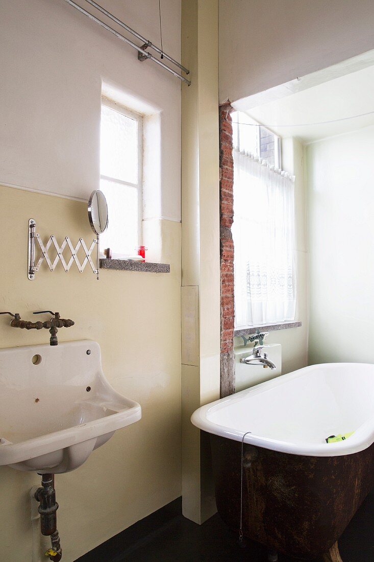 Badezimmer mit alter Wanne und original Ausgussbecken in einer Loft-Wohnung