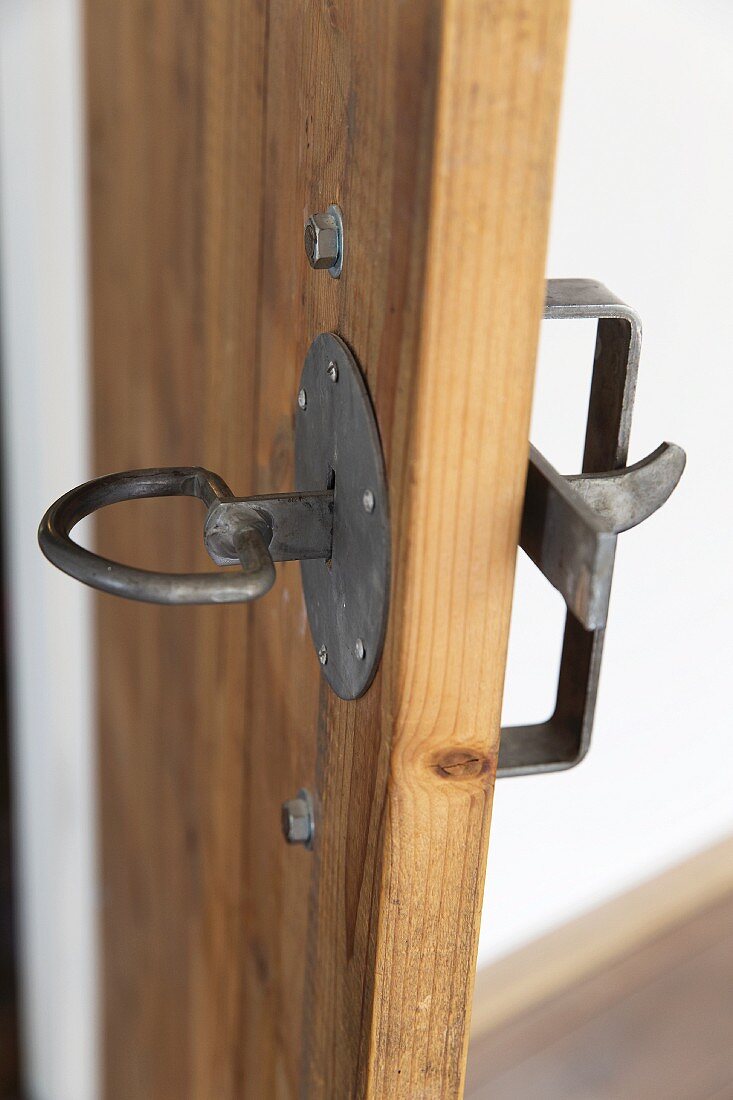 Wrought iron door latch and handle on simple, plain wooden door