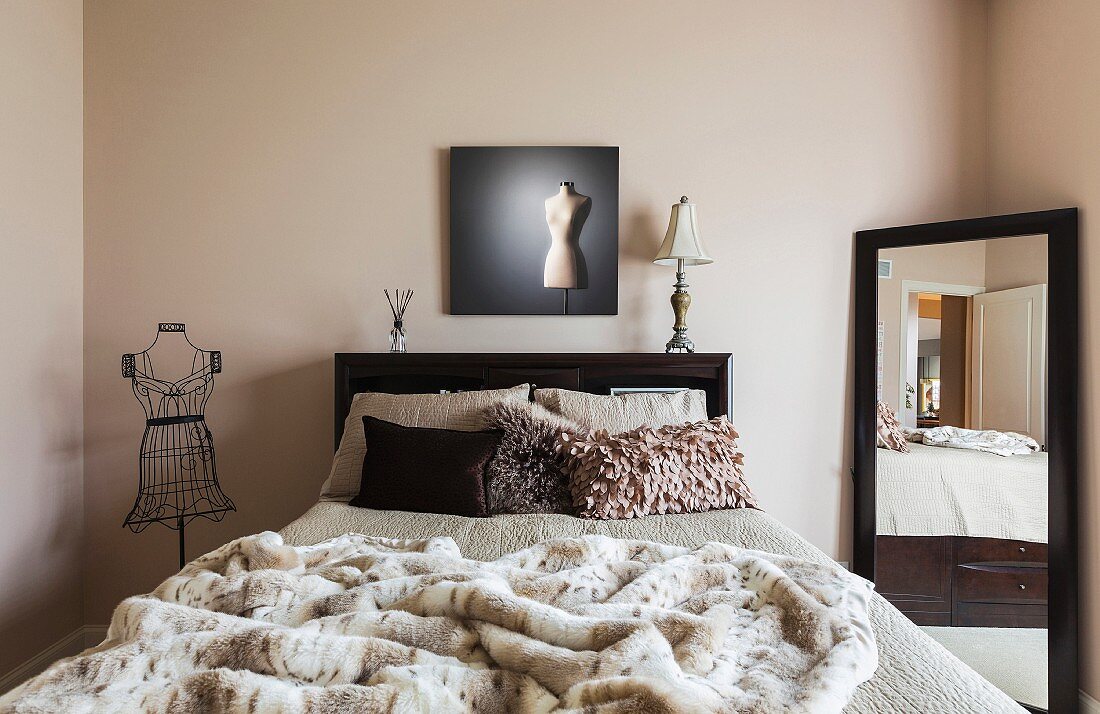 Feminines Schlafzimmer mit großem Spiegel, einer Kleiderpuppe aus Metall und einem Wandbild mit Kleiderpuppenmotiv