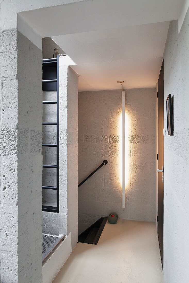 Breeze block walls; hallway with vertical strip light mounted on wall