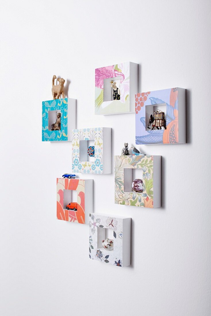 Hand-crafted picture frames used as display cases on wall