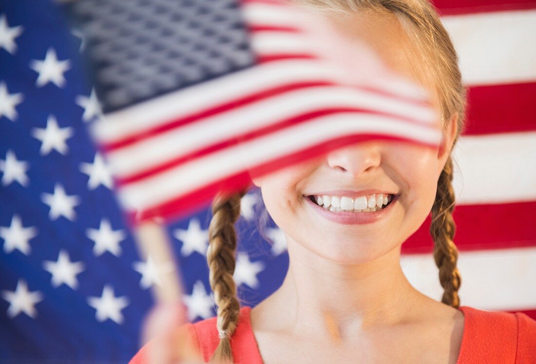 A girl with pigtails between waving flags