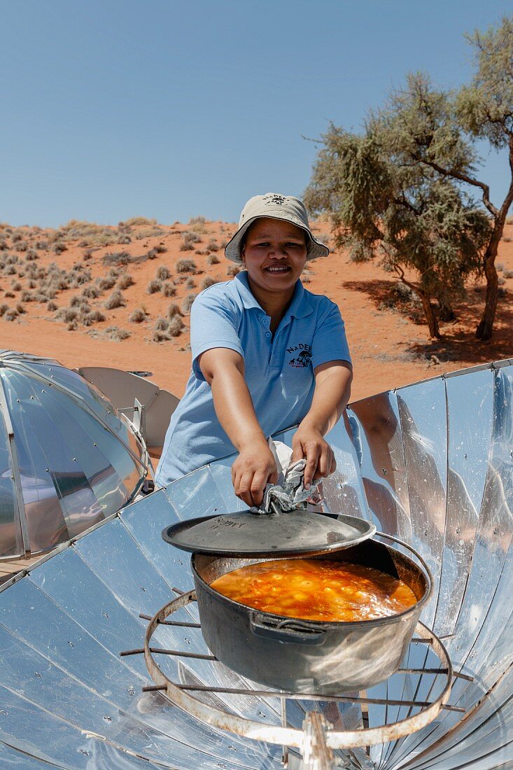 Elisabeth Lammert im NaDEET (Namib Desert Environmental Education Trust) am Solarkocher, NamibRand Privatreservat, Namibia, Afrika