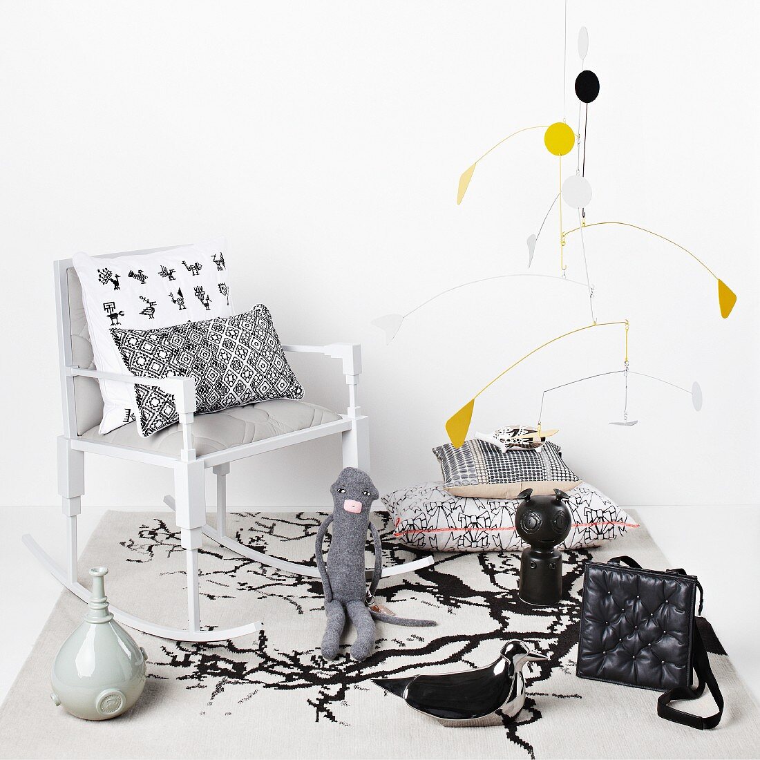 Mobile by Alexander Calder above collection of various figurines, cushions and delicate rocking chair