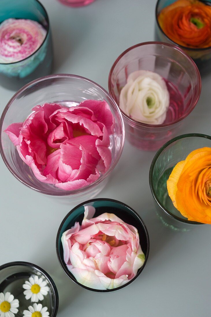 Frühlingsblüten in farbigen Vintage Gläsern als Tischdeko