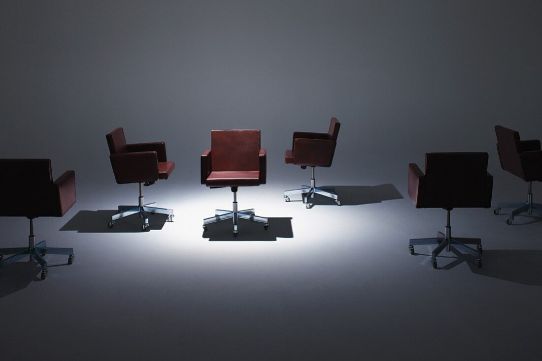 Brown leather swivel chairs under spotlight
