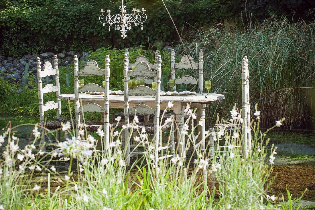 Chandelier above set table standing in pond