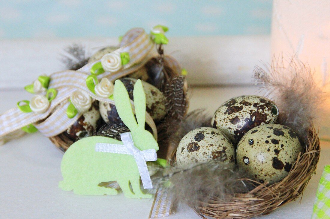 Osternester mit gesprenkelten Eiern dekoriert mit Filzhase