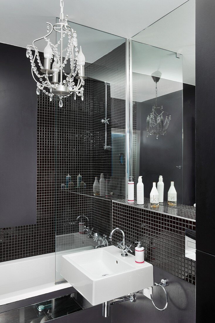 Kleiner Kronleuchter in Designerbad mit schwarzen Mosaiksteinen
