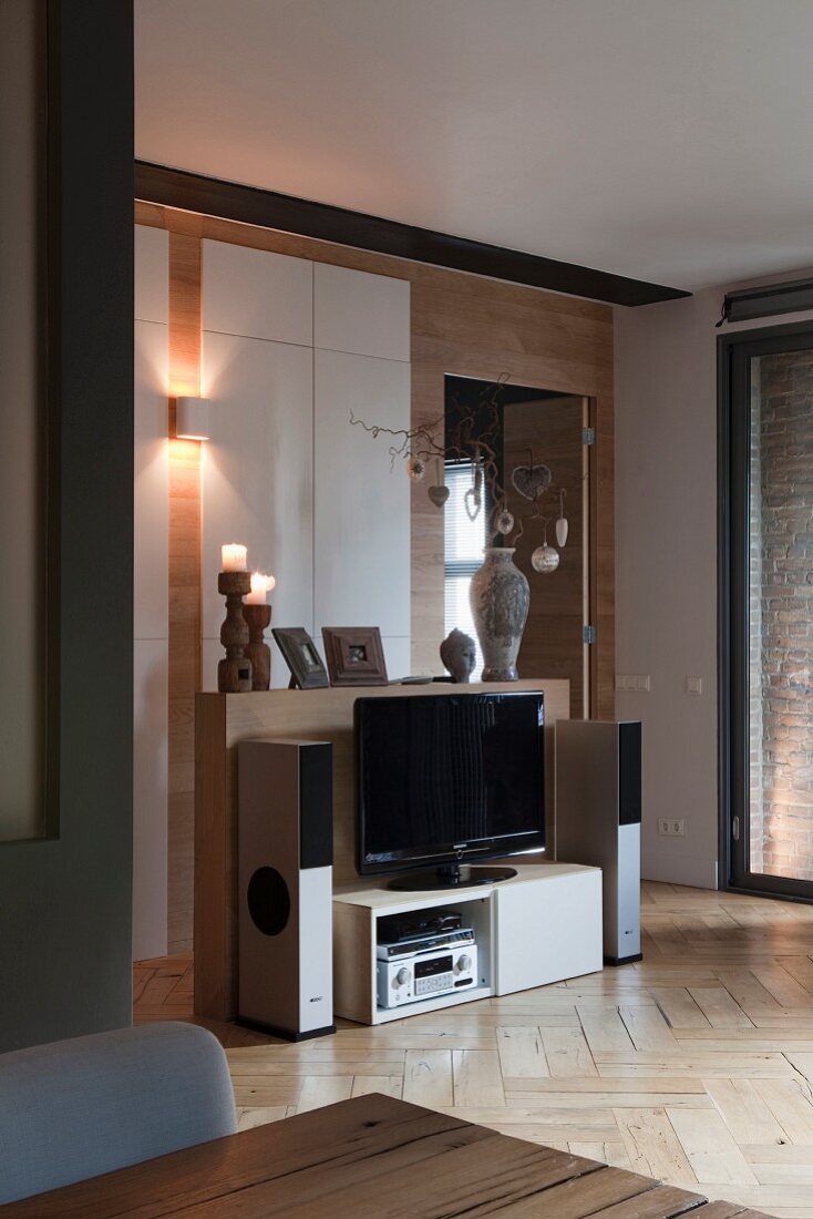 Hi-Fi-Anlage und Flachbildschirm in und auf weißem Lowboard in elegantem Ambiente