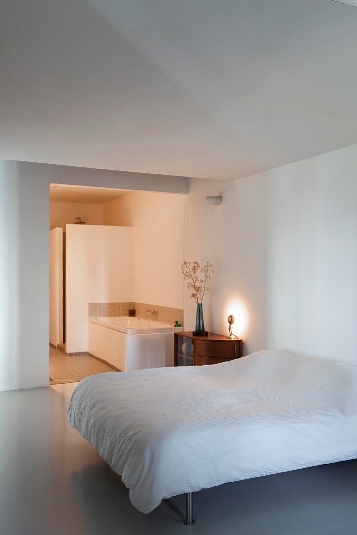 Schlafbereich mit Doppelbett und edlem Sideboard, Blick in Bad Ensuite