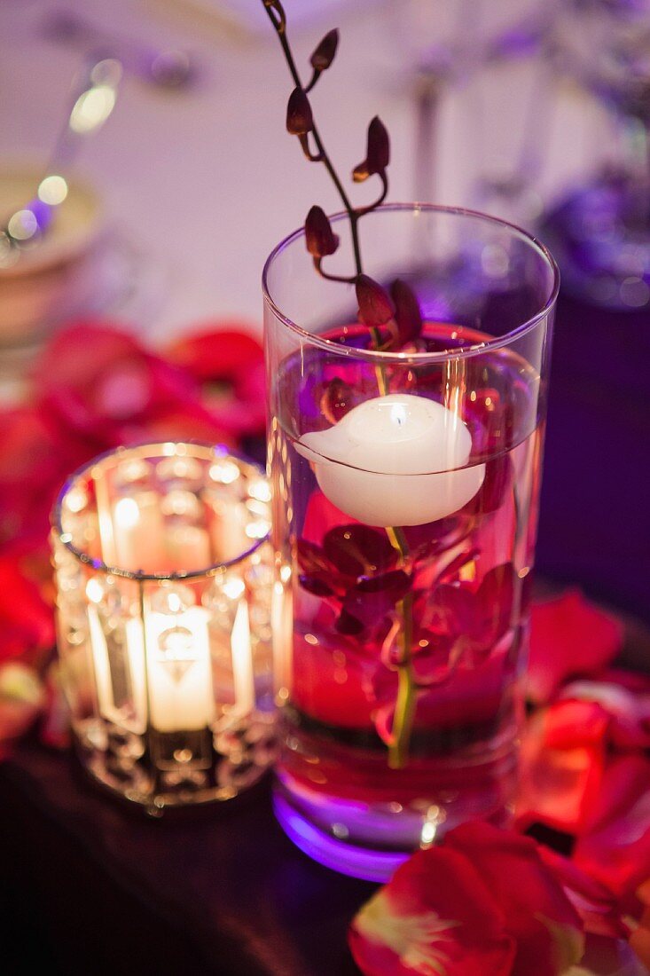 Detail eines Hochzeitstisches mit schwimmender Kerze in einem Wasserglas mit Orchidee