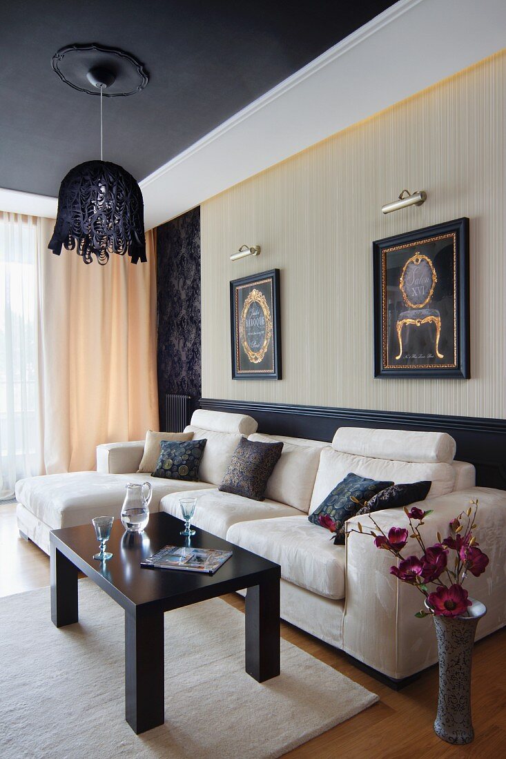 Pendant lamp above pale sofa combination in elegant living room with suspended ceiling