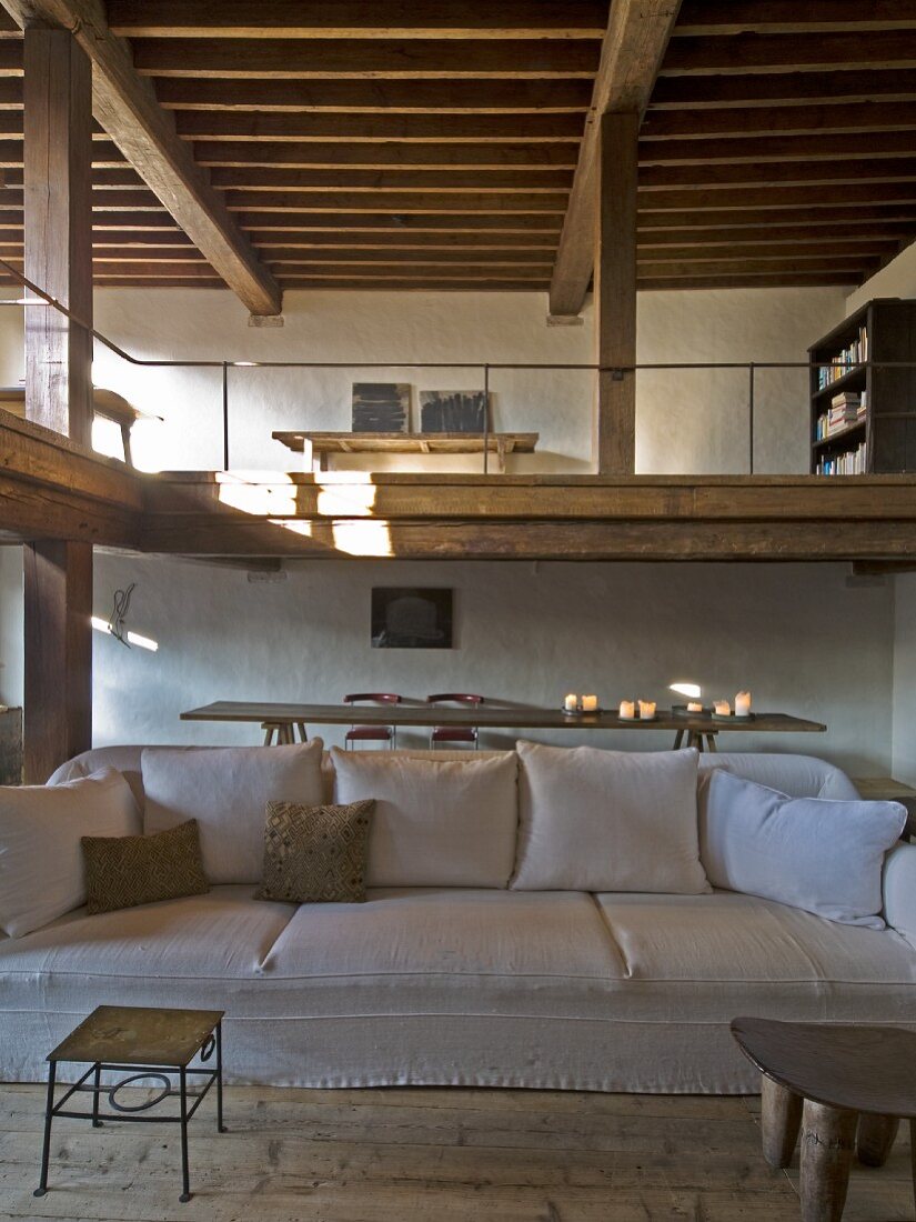 A light upholstered sofa in a rustic living area with a gallery