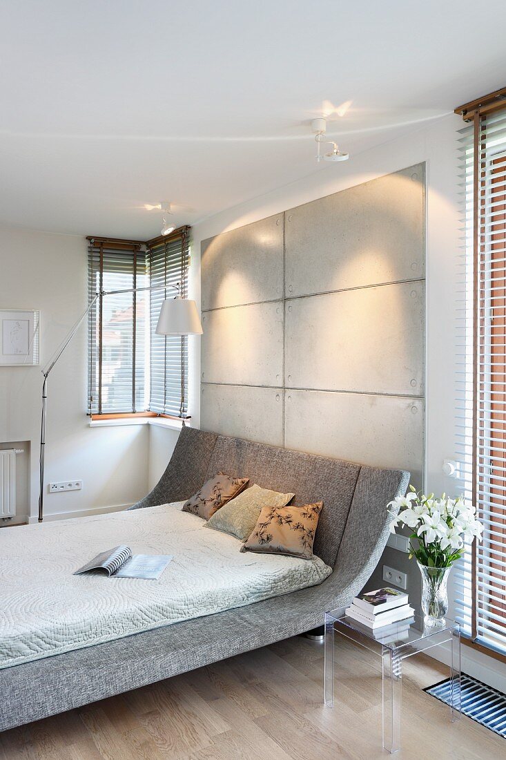 Doppelbett in Designerstil mit gebogenem Kopfteil und grauem Bezug in modernem Schlafzimmer