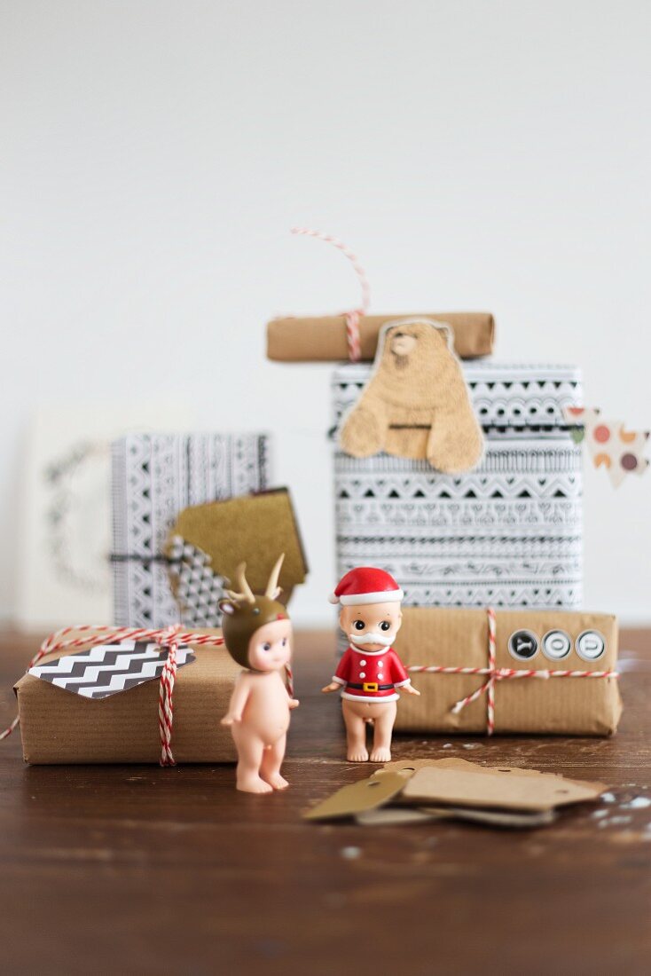 Kleine Weihnachtsfiguren und verpackte Geschenke mit Kärtchen