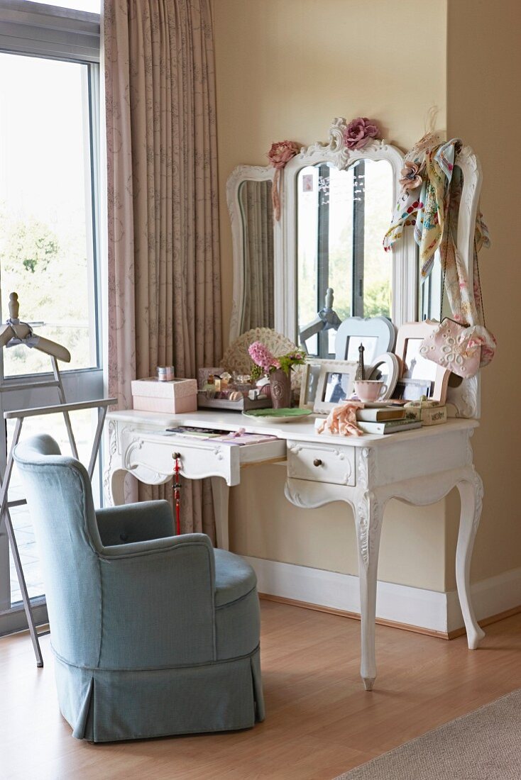 Traditional armchair with blue loose cover at white, antique-style dressing table