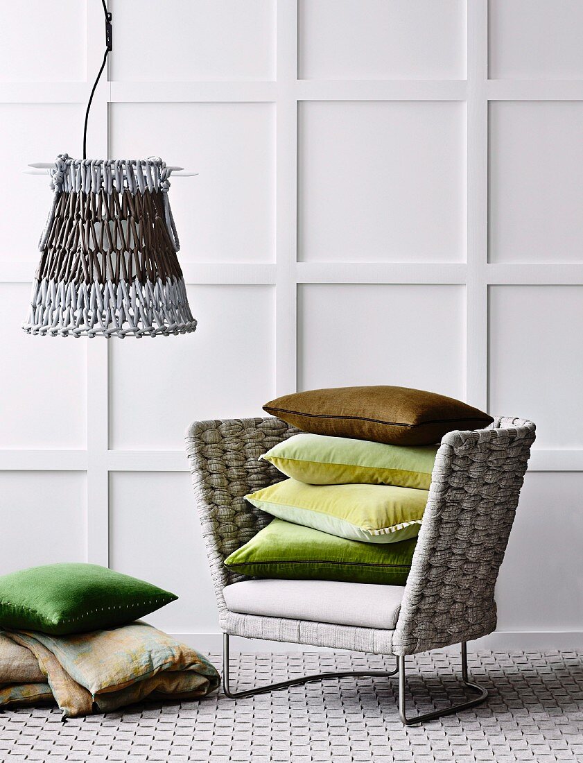 Sessel mit geflochtener Lehne, Teppich aus geflochtenen Bändern und Lampenschirm in Häkeloptik