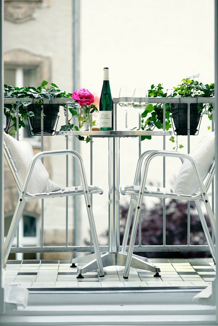 Stainless steel outdoor chairs at bistro table on balcony