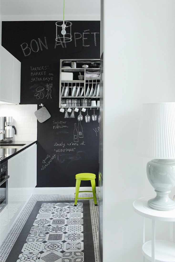 Blick in Küche mit dekorativen schwarz-weissen Bodenfliesen und Tafelwand