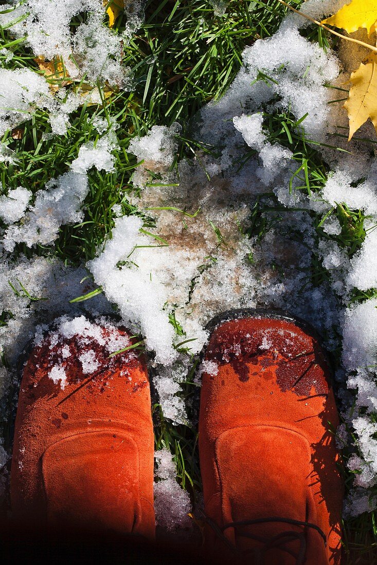 Schuhe im verschneiten Herbstgarten