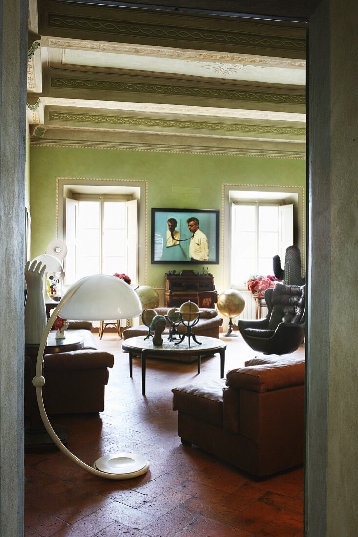 Durchgang zu Wohnraum mit gesammeltem Vintage-Mobiliar und Kunstobjekten in italienischem Renaissancebau