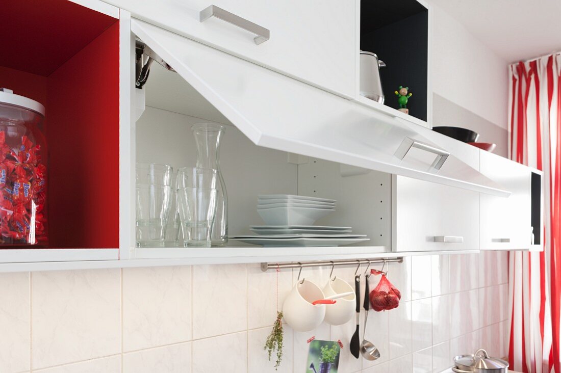 weiße Hängeschränke mit offener Klapptür in renovierter Küche
