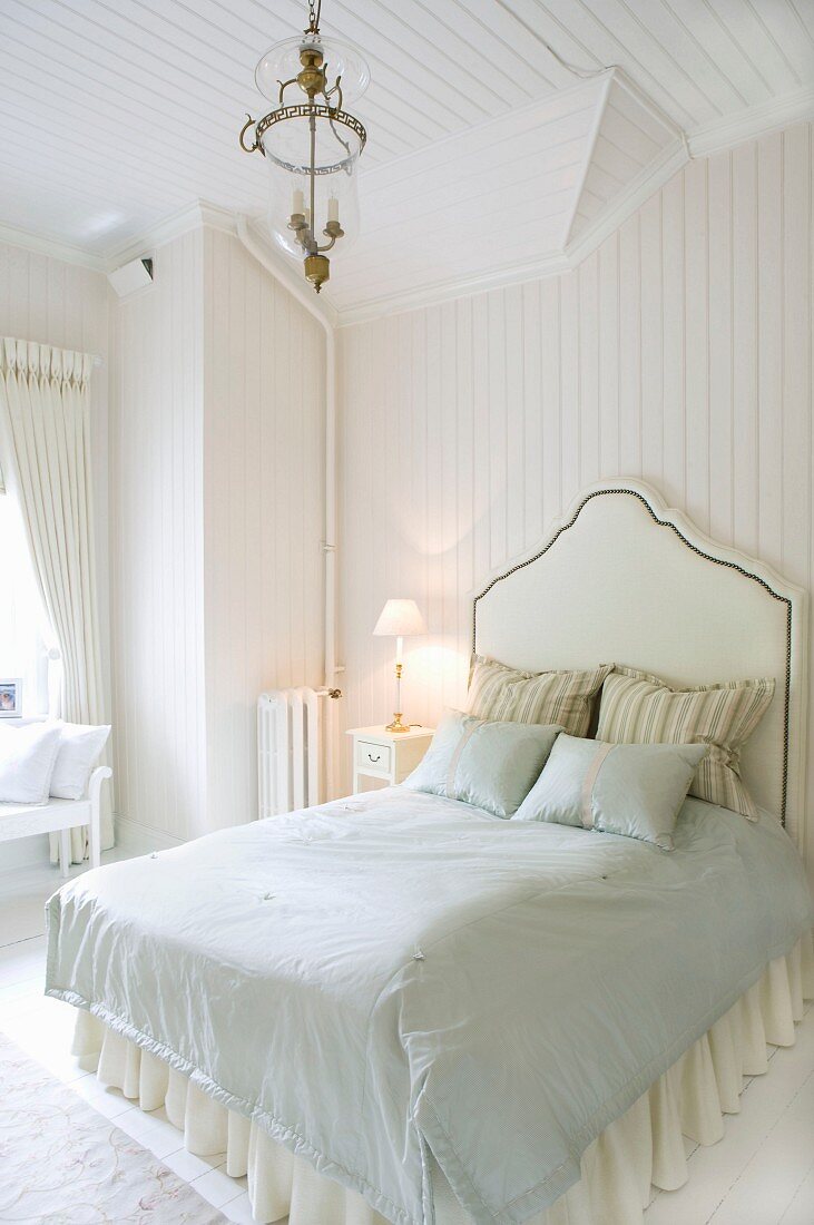 Bed with tall headboard in pale, Scandinavian bedroom in elegant, country-house style