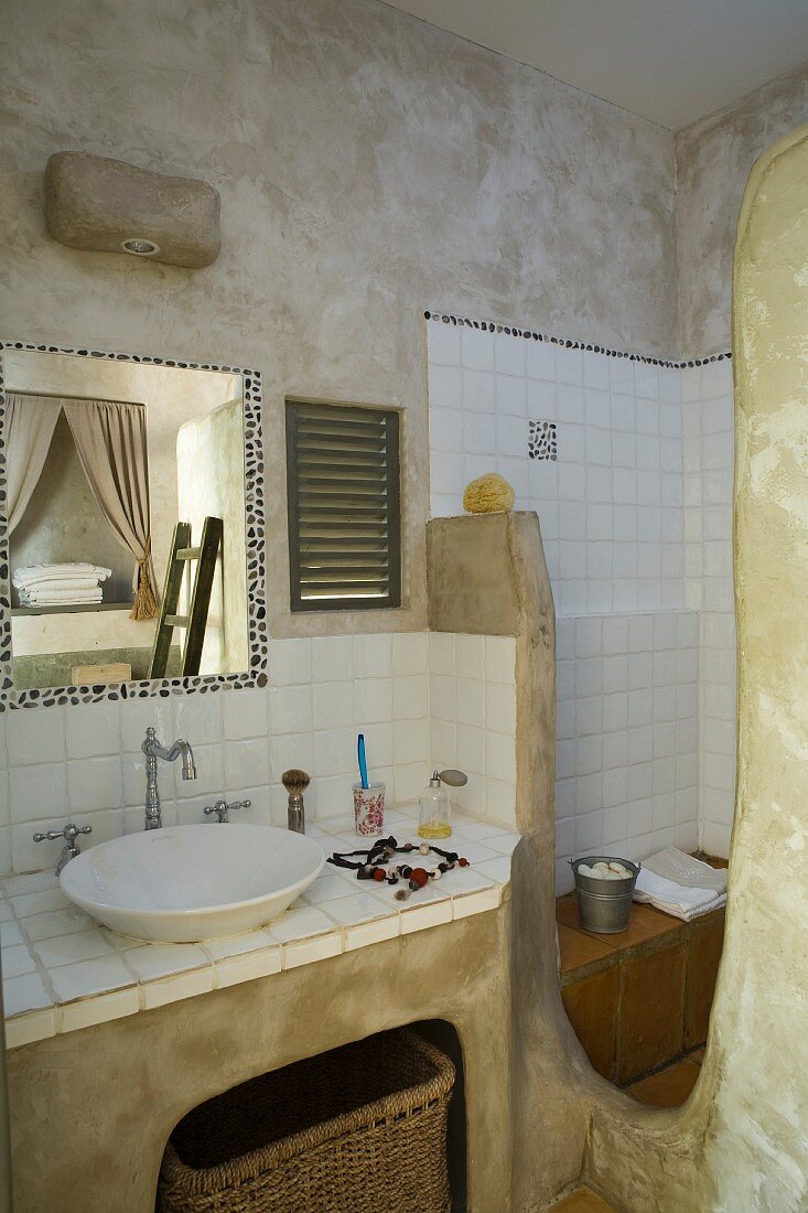 Mit ungebrannter Umbra marmorierte Wände, weiße Fliesen und organisch geformte Wandelemente mit mattgrüner Patina in provenzalischem Badezimmer