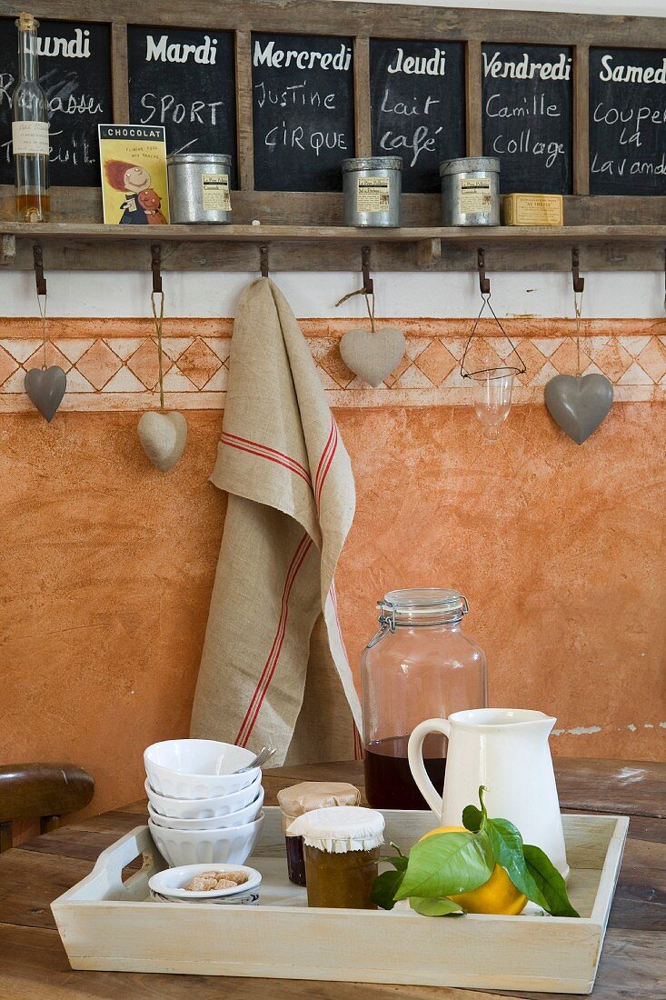 Chalkboard calender, heart-shaped decorations and linen cloth hanging from hook; fresh lemons on breakfast tray on foreground