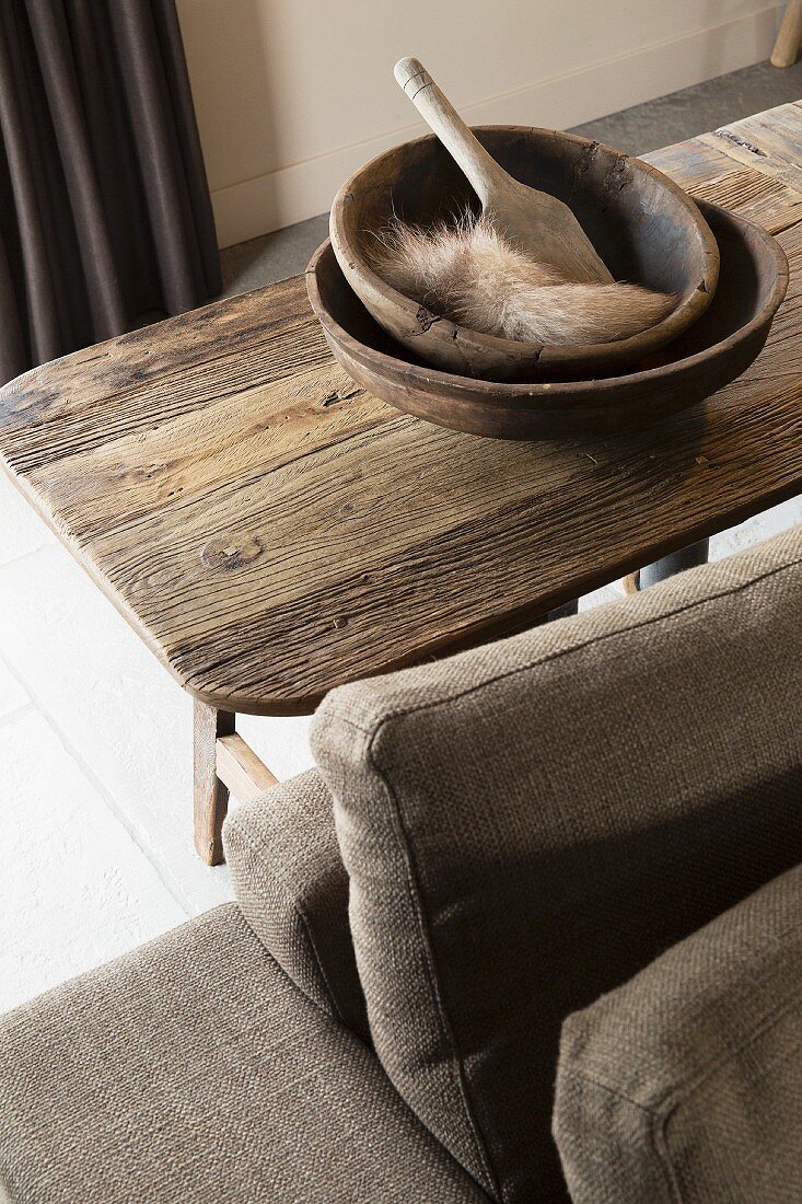 Holzschalen, Holzschaufel und Fellstück auf rustikalem Tisch