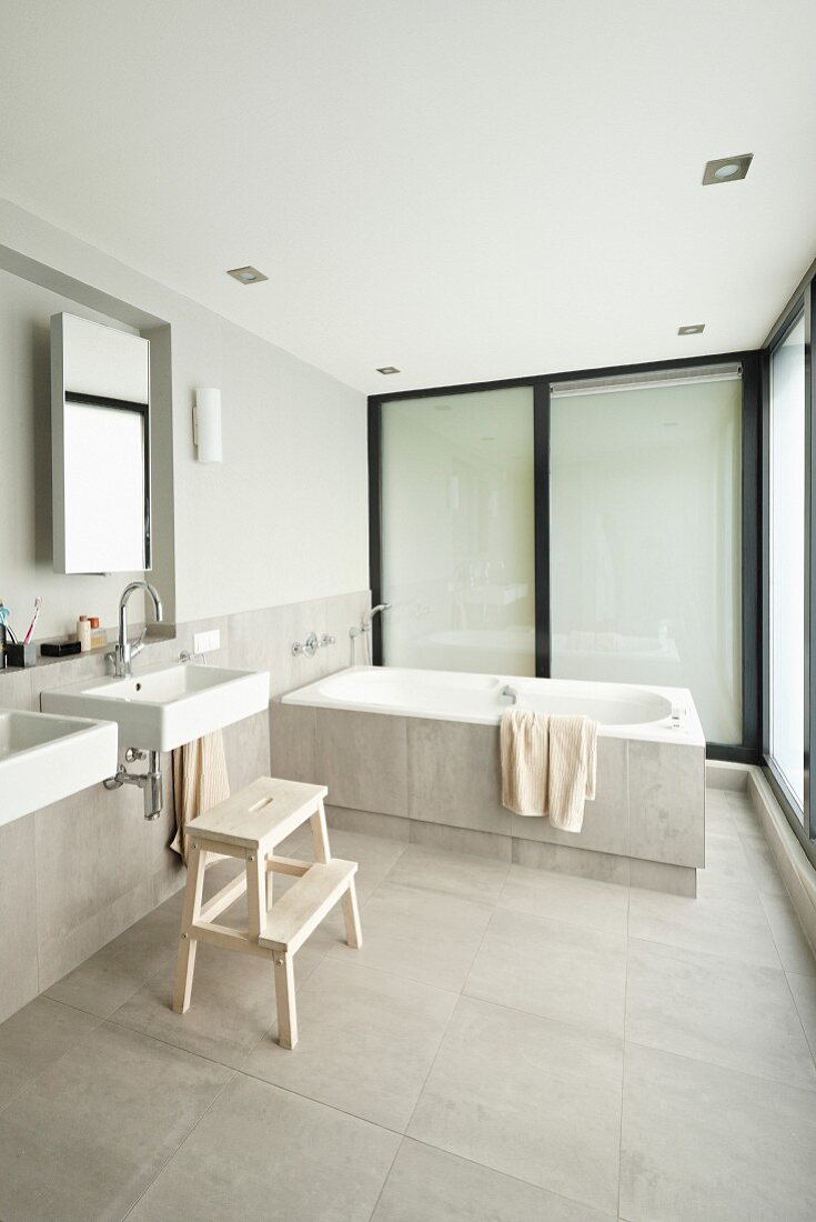 Minimalistisches Designerbad, Waschbecken an halbhoher Brüstungswand und Badewanne