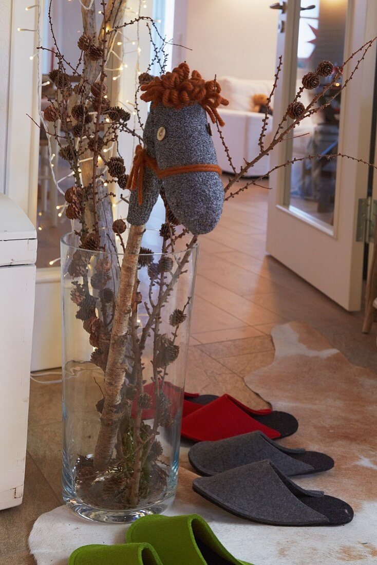 Selbst gemachtes Sockensteckenpferd in weihnachtlich dekorierte Vase und Gästepantoffel aus Filz