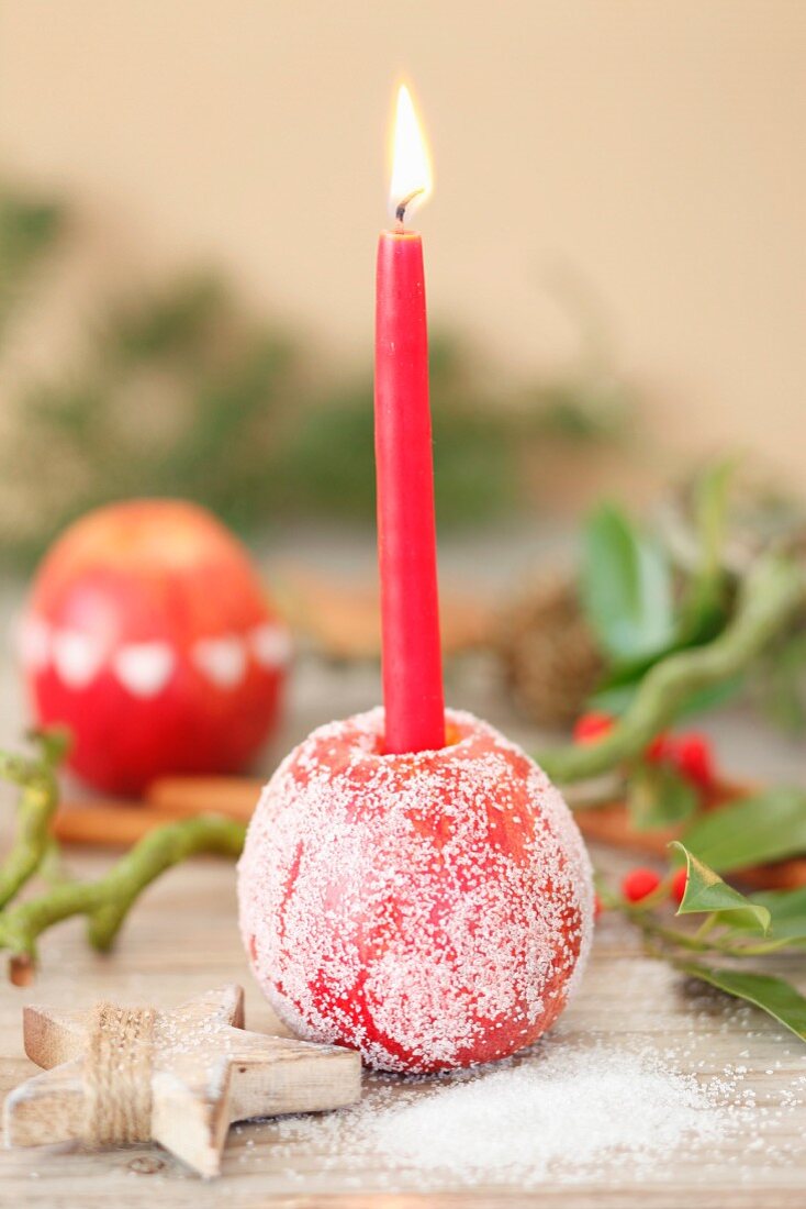 Gezuckerter Apfel als weihnachtlicher Kerzenhalter