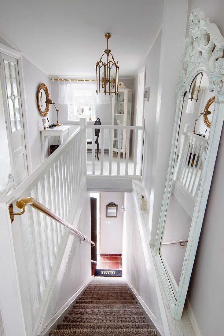 Dramatic view down staircase with white wooden balustrade