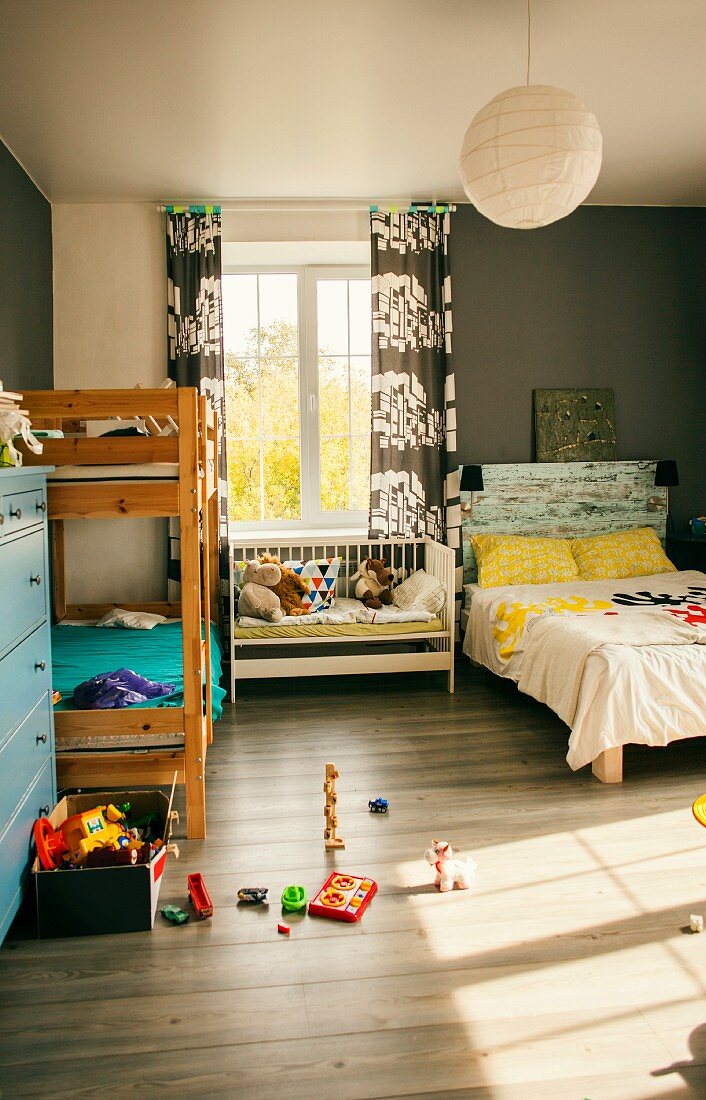 Kinderzimmer mit Bett, Stockbett & Sitzbank vor Fenster