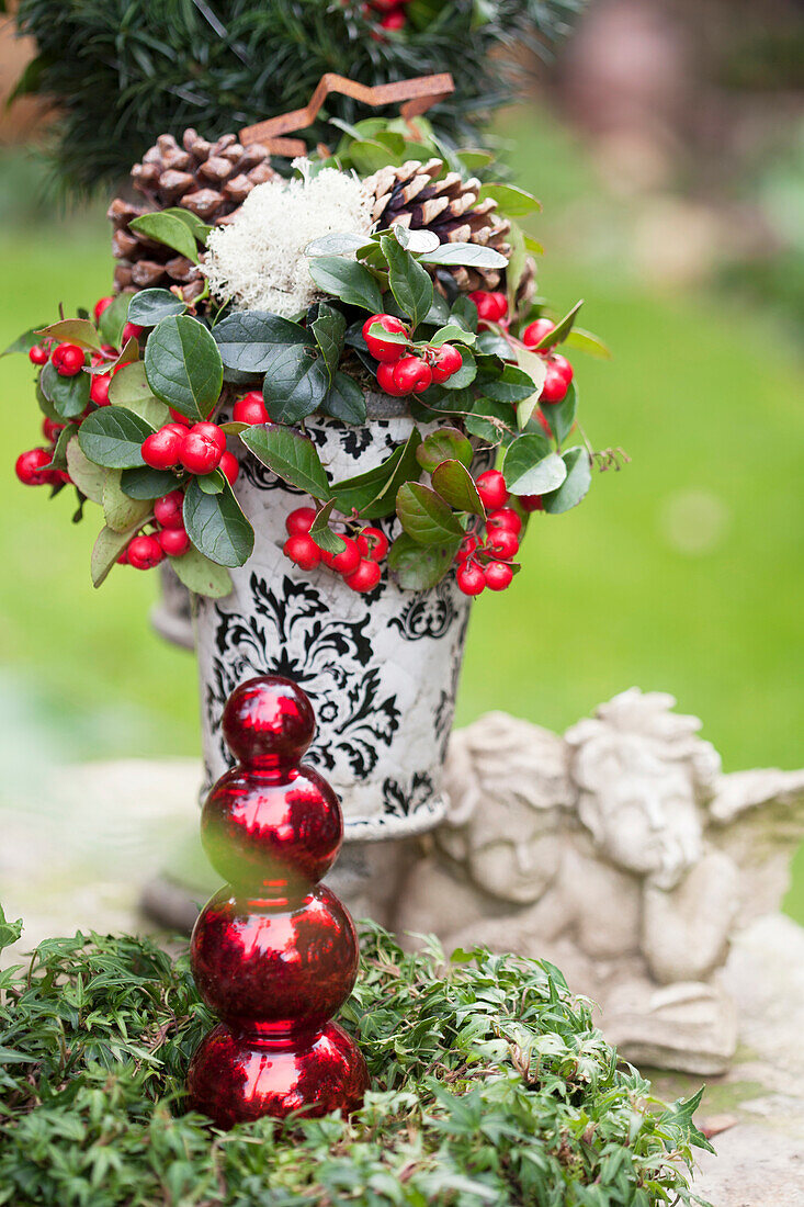 Weihnachtliches Gesteck in antiker Vase und Engelfiguren aus Stein