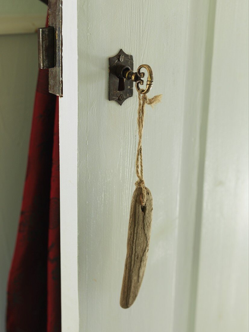 Key with wooden key fob in lock of wooden door