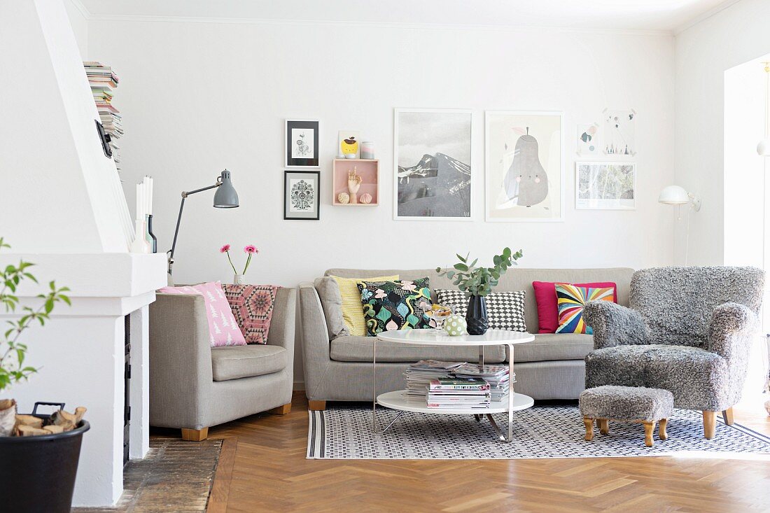Sofagarnitur und gemütlicher Sessel mit grauem Flauschstoff Bezug, passender Fussschemel auf Teppich in Wohnzimmer