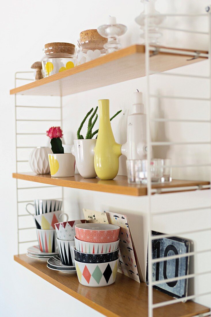 Geschirr mit farbigem Retro Muster, Vasen und Aufbewahrungsbehälter im String Wandregal