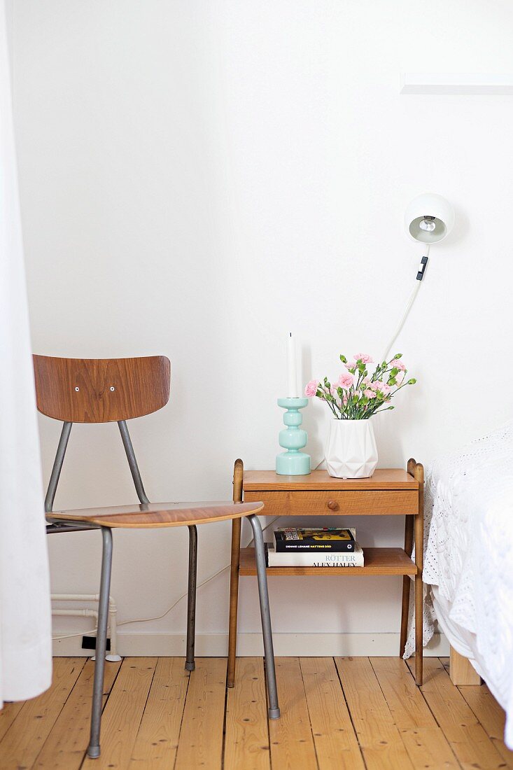 Wooden chair with metal frame next to small, wooden, fifties-style side table