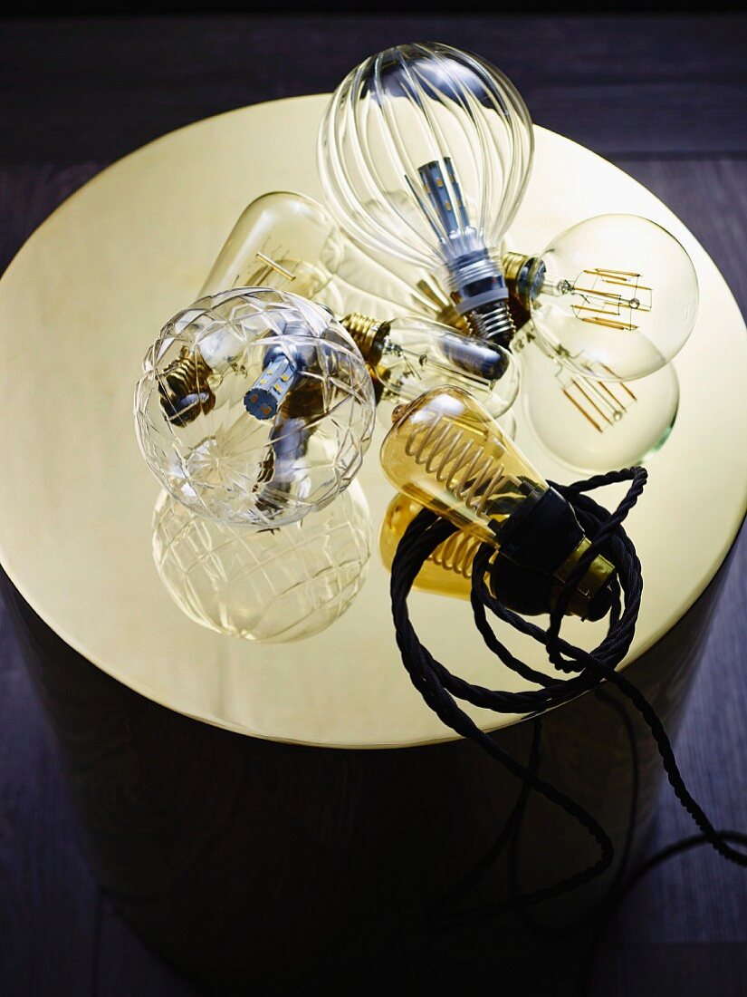 Various light bulbs on shiny gold panel