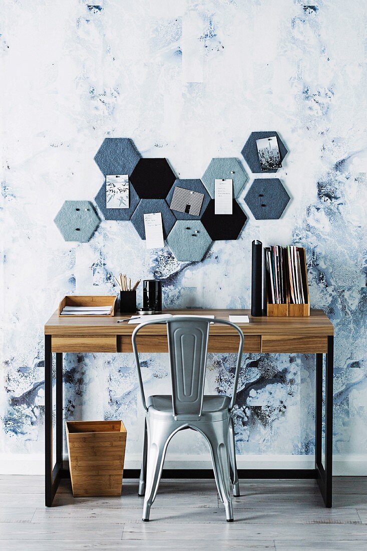 Honeycomb-shaped DIY pin board above desk with vintage chair
