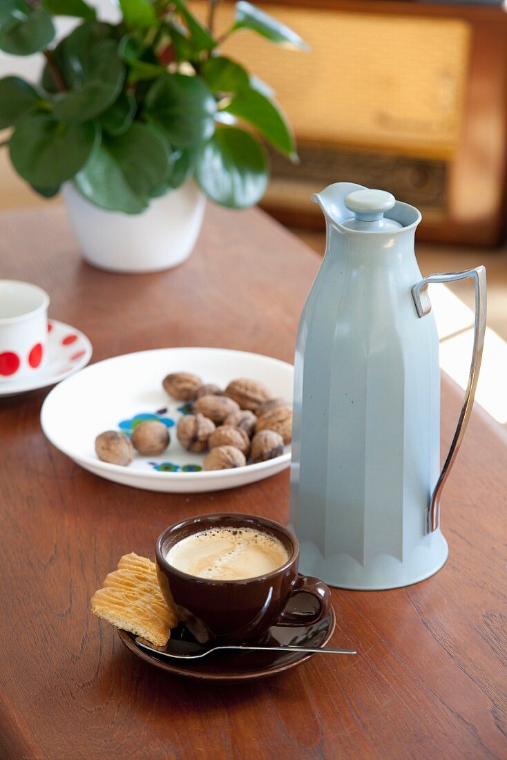 Cup of espresso and pale blue thermos jug
