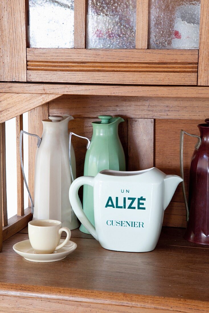Ceramic jug and pastel, retro thermos jugs on dresser