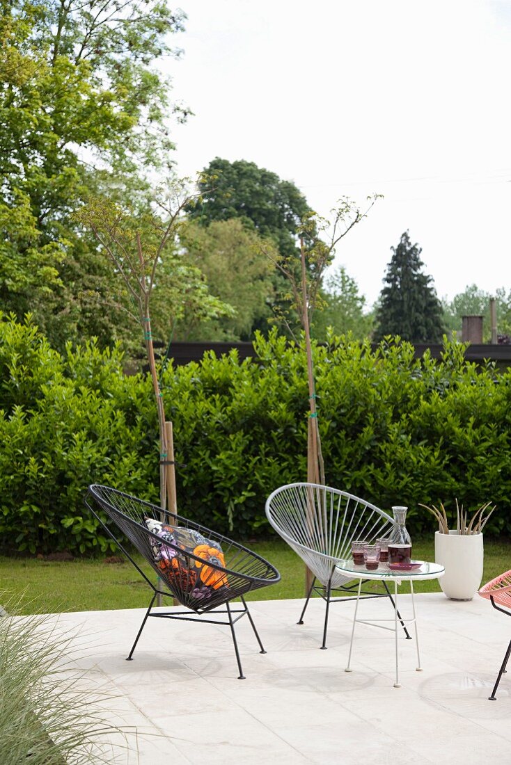 Retro Schalenstühle mit Schnurbespannung und Beistelltisch auf Terrasseplatz im Garten