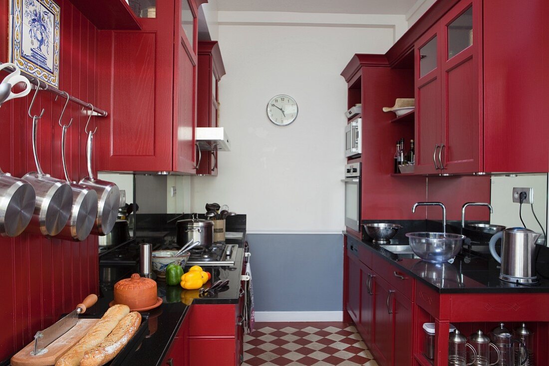 Zweizeilige Küche mit rot lackierten Küchenschränken im Landhausstil, Schachbrettmusterboden
